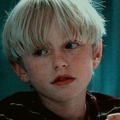 a young boy with blonde hair and blue eyes