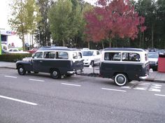 an old black and white van being towed by a tow truck