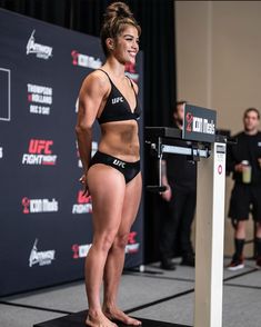 a woman standing on top of a black platform