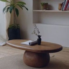 a wooden table sitting on top of a hard wood floor next to a book shelf