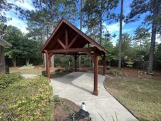 a wooden gazebo sitting in the middle of a park