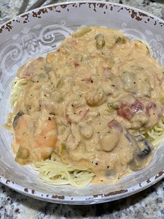 pasta with shrimp and cream sauce in a bowl on a marble countertop, ready to be eaten