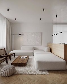 a modern living room with white furniture and wood accents on the walls, along with a wooden coffee table