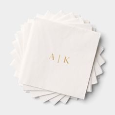 six white napkins with gold letters and the word a / k on them, stacked together