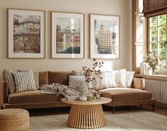 a living room filled with furniture and pictures hanging on the wall above a coffee table