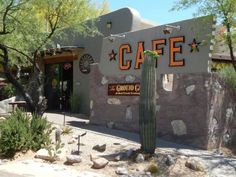 the entrance to cafe conitoo c with cactus in foreground and mountains in background