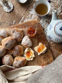 pastries on a cutting board next to a cup of tea