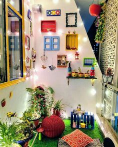 a room filled with lots of plants and pictures on the wall next to a window