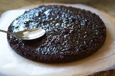 a spoon sitting on top of a chocolate cake