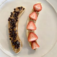 a banana split with chocolate chips and strawberries on it sitting on a white plate