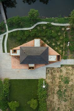 an aerial view of a house in the middle of a grassy area with lots of trees