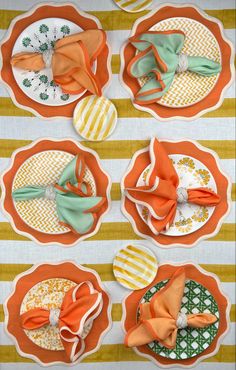 four orange and green plates with bows on them