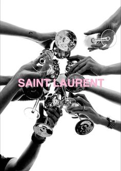 hands holding wine glasses with the words saint laurent