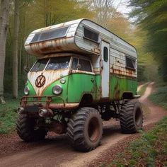 an old green and white camper van driving down a dirt road in the woods