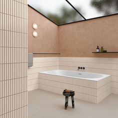 a bath room with a large white tub next to a walk in shower and a wooden stool