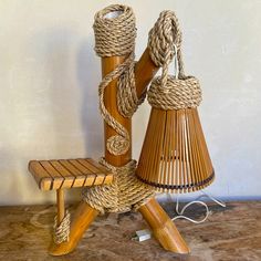 a wooden bench with rope wrapped around it and two baskets on the back, sitting next to each other