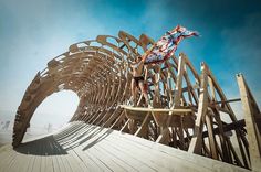 a man riding a surfboard on top of a wooden structure