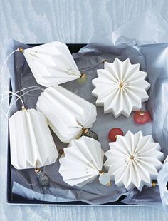 several white paper flowers are on a tray