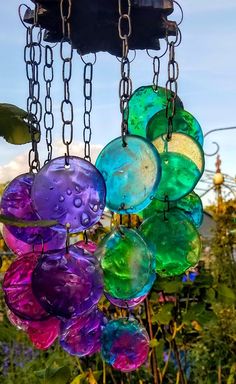 a wind chime hanging from the side of a tree with lots of colorful glass balls