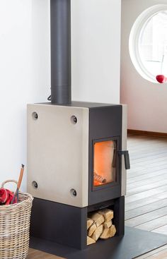 a wood burning stove sitting on top of a wooden floor next to a basket with apples