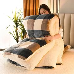 a woman laying on top of a bed covered in pillows