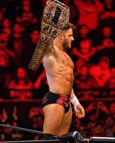 a man with a helmet on top of his head standing next to a wrestling ring