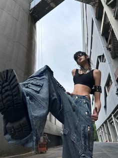 a woman standing in front of a tall building with her jeans hanging out to dry