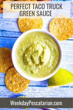 the perfect taco truck green sauce in a white bowl surrounded by crackers and limes