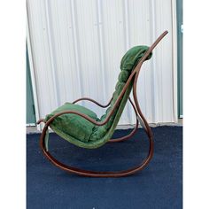 a green chair sitting on top of a blue carpet next to a white wall and door