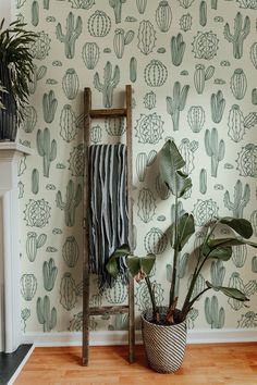 a room with cactus wallpaper and a plant in a pot next to a ladder