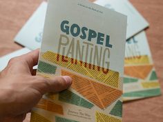 a person holding up a book that says gospel painting