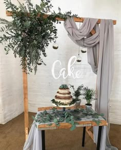 a cake sitting on top of a wooden table next to a green plant covered wall