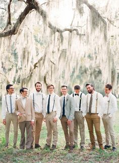 a group of young men standing next to each other in front of a large tree