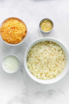 ingredients for cheese dip in bowls on a white marble countertop with condiments