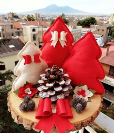 red and white christmas decorations sit on top of a tree stump in front of a cityscape