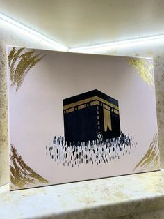 a painting of the ka'bah in gold and black on a pink background