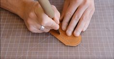 a person is cutting something with a pair of scissors on a piece of wood that has been cut into smaller pieces