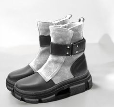 These women's boots are the perfect combination of modernity and comfort. Made from genuine leather, they feature an elegant yet practical sole that ensures comfort throughout the day. An asymmetric piece of velour wraps around the upper part of the boot, giving it a unique and distinctive look. A beautiful belt at the top adds sophistication and style. The model is closed with a zipper, making it easy to wear and put on. This is the perfect choice for everyday wear, combining comfort and modern Ankle-high Platform Boots With Buckle Closure For Winter, Ankle-high Platform Boots With Buckle Closure Punk Style, Ankle-high Faux Leather Platform Boots With Buckle, Edgy Ankle-high Moto Boots With Zipper Closure, Black Punk Mid-calf Boots With Buckle Closure, Black And White Boots, White Ankle Boots, Elegant Gift Wrapping, Womens Booties