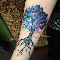 a tree tattoo on the arm with stars and galaxy in the sky, done by david rocklin