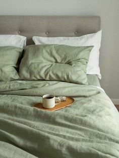 a bed with two pillows and a cup on it