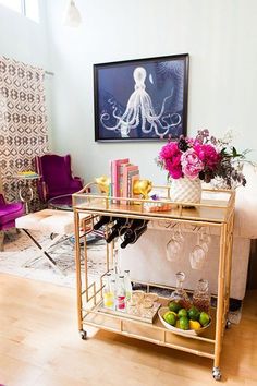 a living room filled with furniture and a painting on the wall next to a coffee table