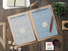 a desk with two planner pages and a pen next to it on top of a wooden table