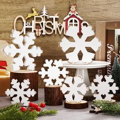 snowflake cutouts sitting on top of a table next to christmas decorations and presents