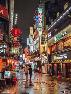 two people walking down a street in the rain