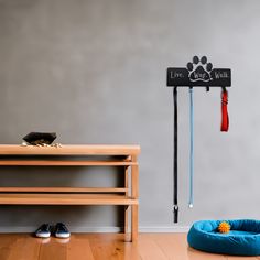 a dog bed and coat rack in the corner of a room with shoes on the floor