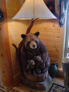 there is a bear statue with two cubs on the base and a lamp next to it