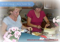 two women sitting at a table with cake and flowers in front of them, one cutting the cake