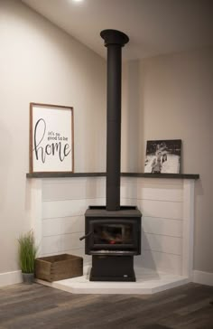 a wood burning stove sitting inside of a living room next to a wooden box on the floor