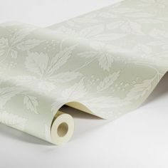 a white wallpaper with floral designs on it's edges and the bottom half rolled up