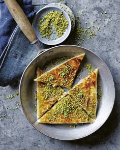 four pieces of flatbread with pistachio cheese and green seasoning on top